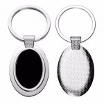 Chaveiro de metal oval, com detalhe preto espelhado.